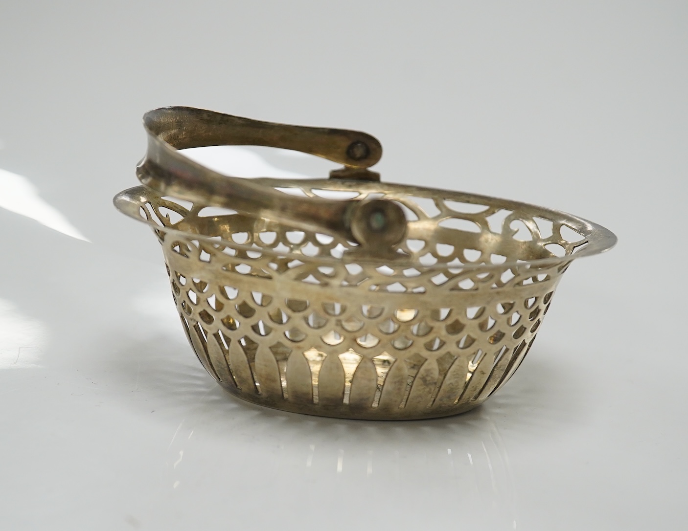 A pair of Edwardian pierced white metal dishes embossed with cherubs, a pair of two handled silver oval bowls, Birmingham, 1936 and two small baskets, one silver one 800 standard. Condition - poor to fair